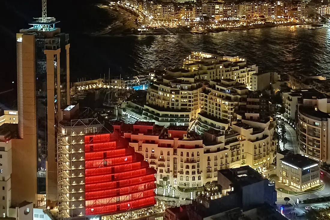 St Julian's and Paceville lit up at night, seen from above, with the sea behind