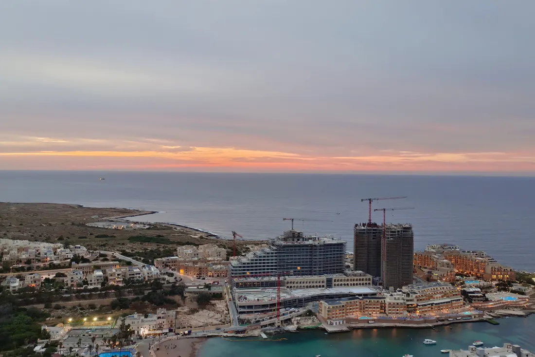 The resort strip at St Paul's Bay and Qawra at dusk, seen from above