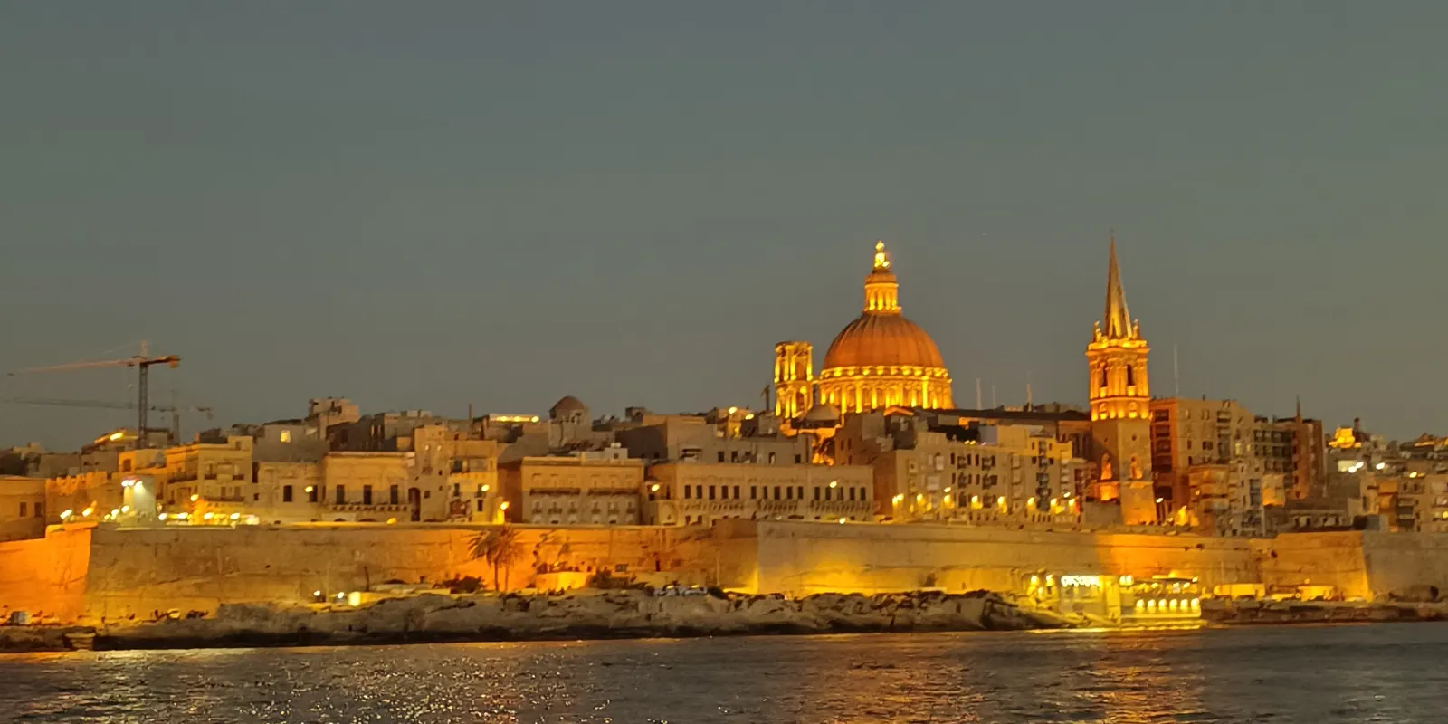 The Valletta skyline lit at night, seen across the water from Sliema