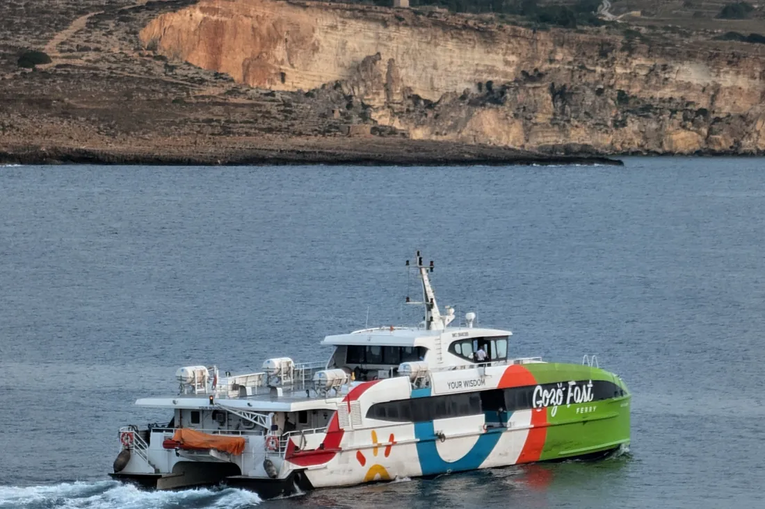 The Gozo fast ferry crossing the channel with the cliffs of Comino behind